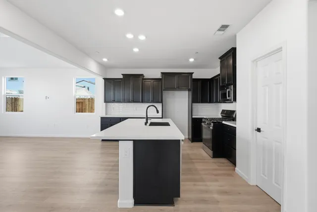 a kitchen with stainless steel appliances granite countertop a sink stove and refrigerator
