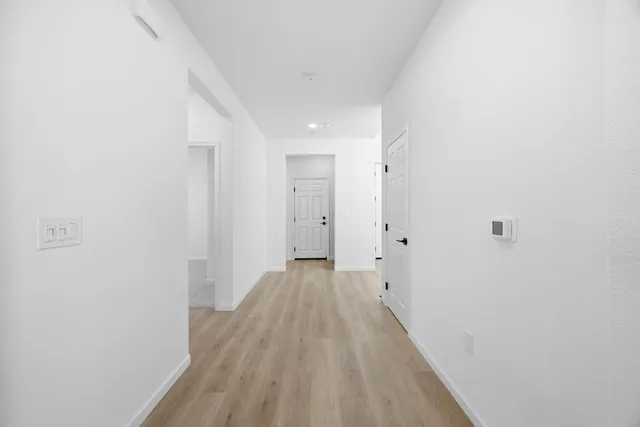 a view of a room with wooden floor and a hallway