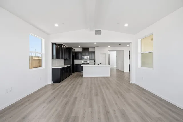 a large kitchen with cabinets wooden floor and stainless steel appliances