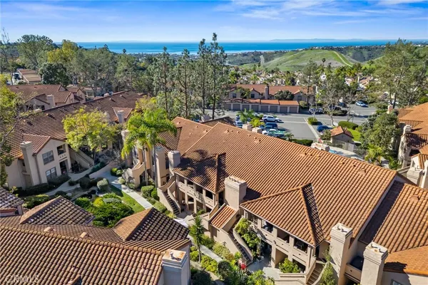 a view of a white house with large windows and a small yard