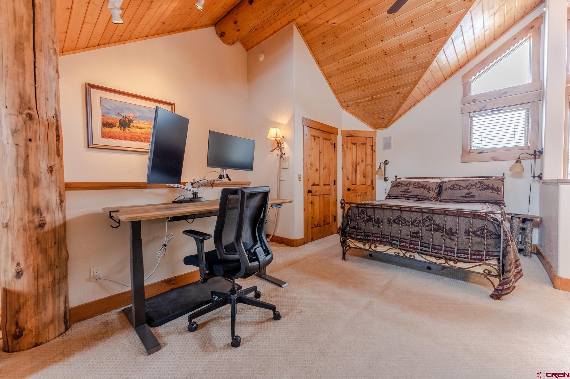 16 Snowmass Road, Unit 4 Crested Butte, CO 81225 - Photo 20 of 35 a bedroom with bed and a chandelier