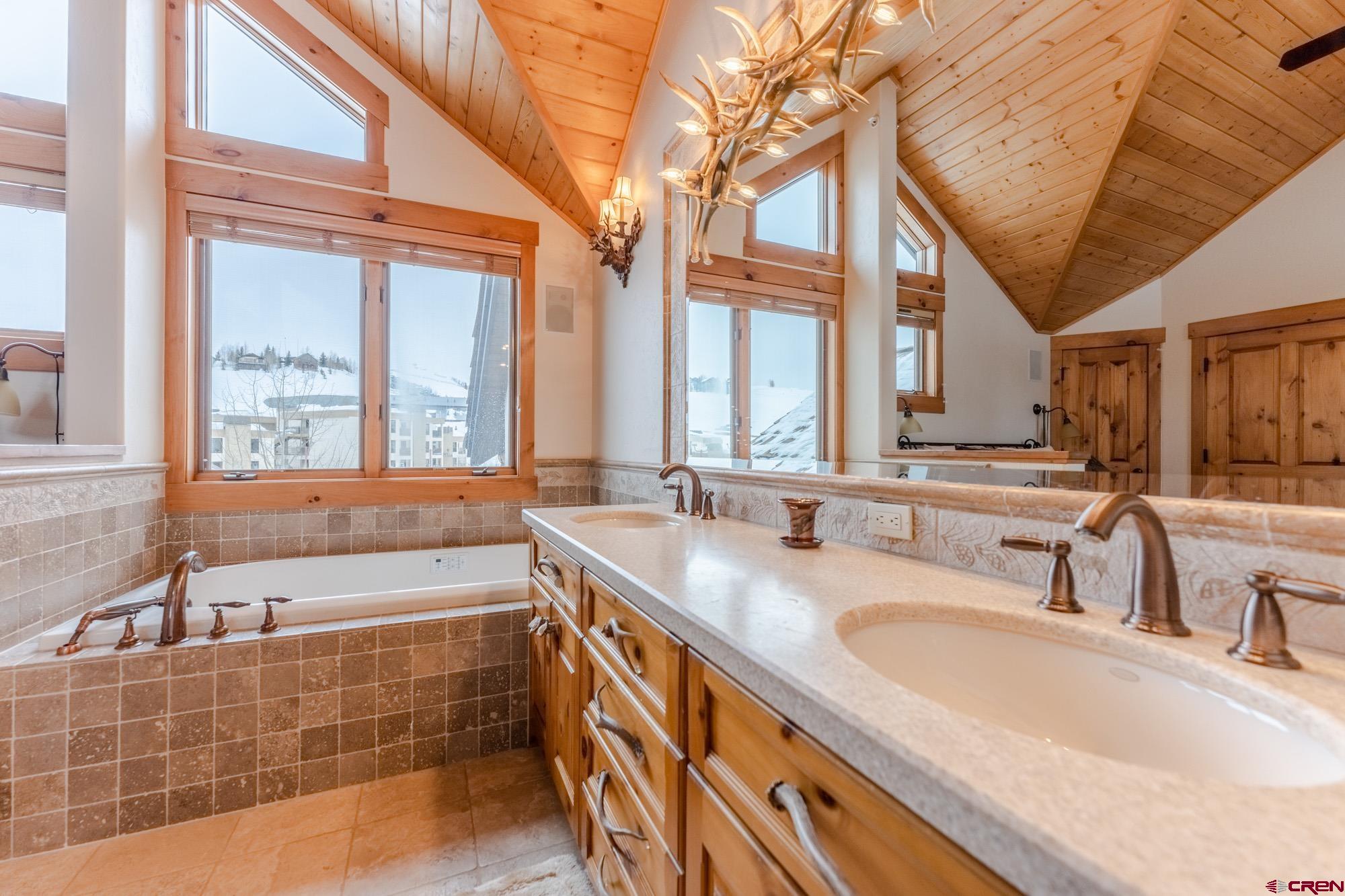 16 Snowmass Road, Unit 4 Crested Butte, CO 81225 - Photo 23 of 35 a bathroom with a granite countertop sink and a large mirror
