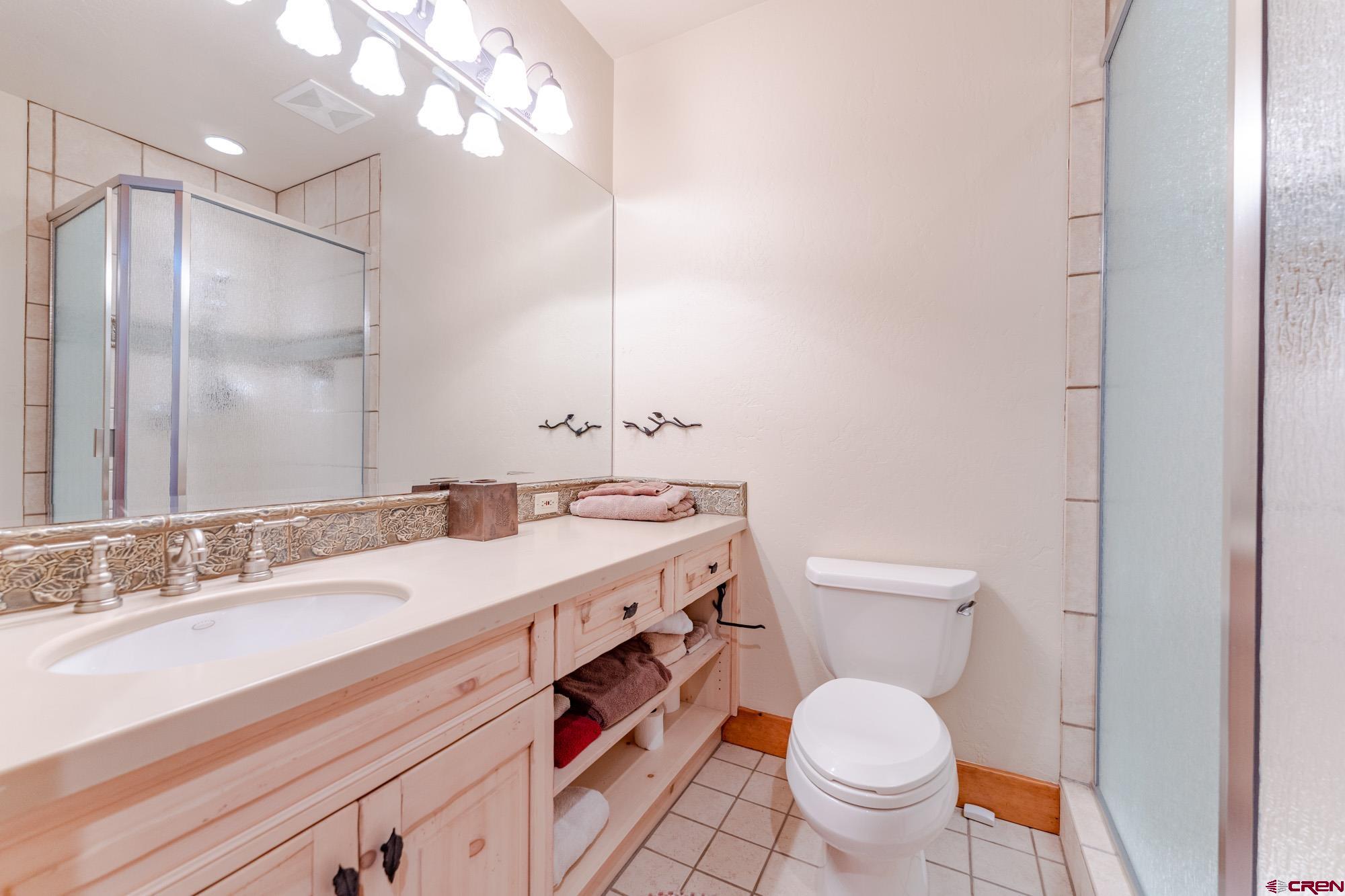 16 Snowmass Road, Unit 4 Crested Butte, CO 81225 - Photo 33 of 35 a bathroom with a granite countertop toilet sink and mirror