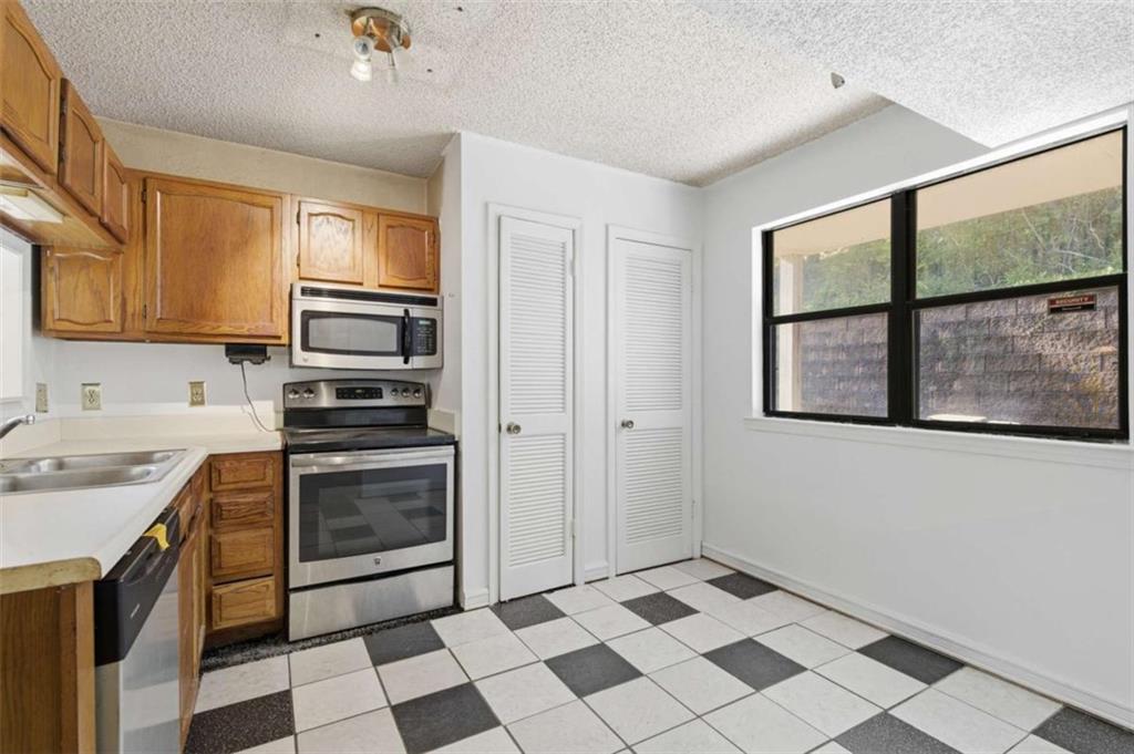 1980 Variations Drive Northeast Atlanta, GA 30329 - Photo 11 of 26 a kitchen with a stove a sink and a refrigerator