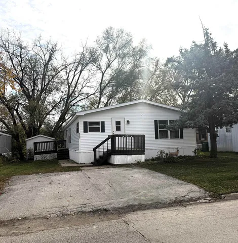 a view of a house with a big yard and large trees