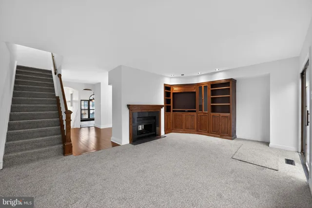 a view of empty room with fireplace and stairs