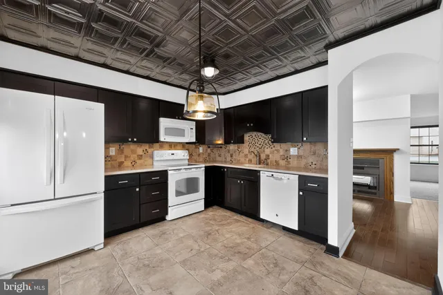a large kitchen with a stove a refrigerator and a sink