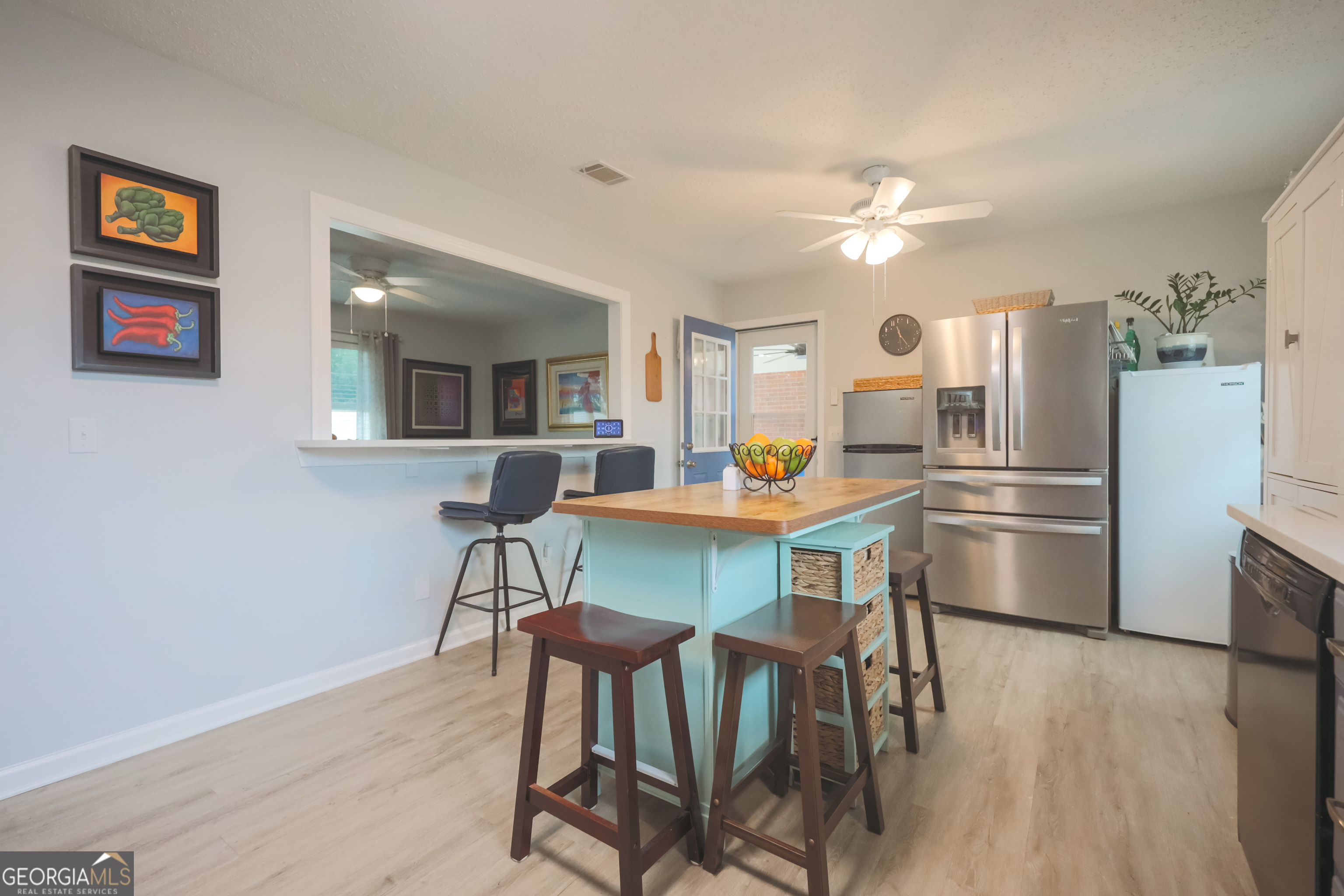 106 Beaver Drive Blackshear, GA 31516 - Photo 12 of 20 a kitchen with stainless steel appliances a refrigerator a stove a dining table and chairs with wooden floor