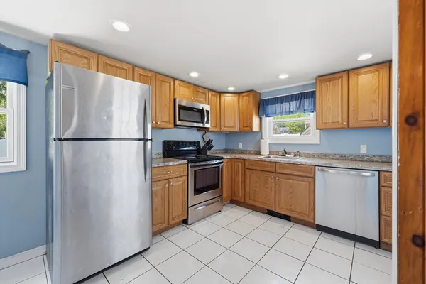 a kitchen with stainless steel appliances granite countertop a refrigerator sink and stove