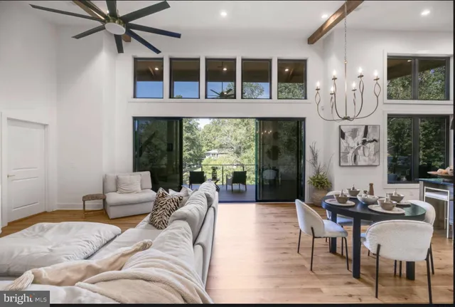 a kitchen with stainless steel appliances kitchen island granite countertop a stove a sink a dining table and chairs with wooden floor