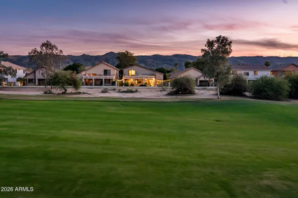 a front view of a house with a garden and mountain view