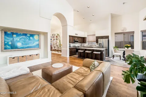 a living room with furniture kitchen view and a large window