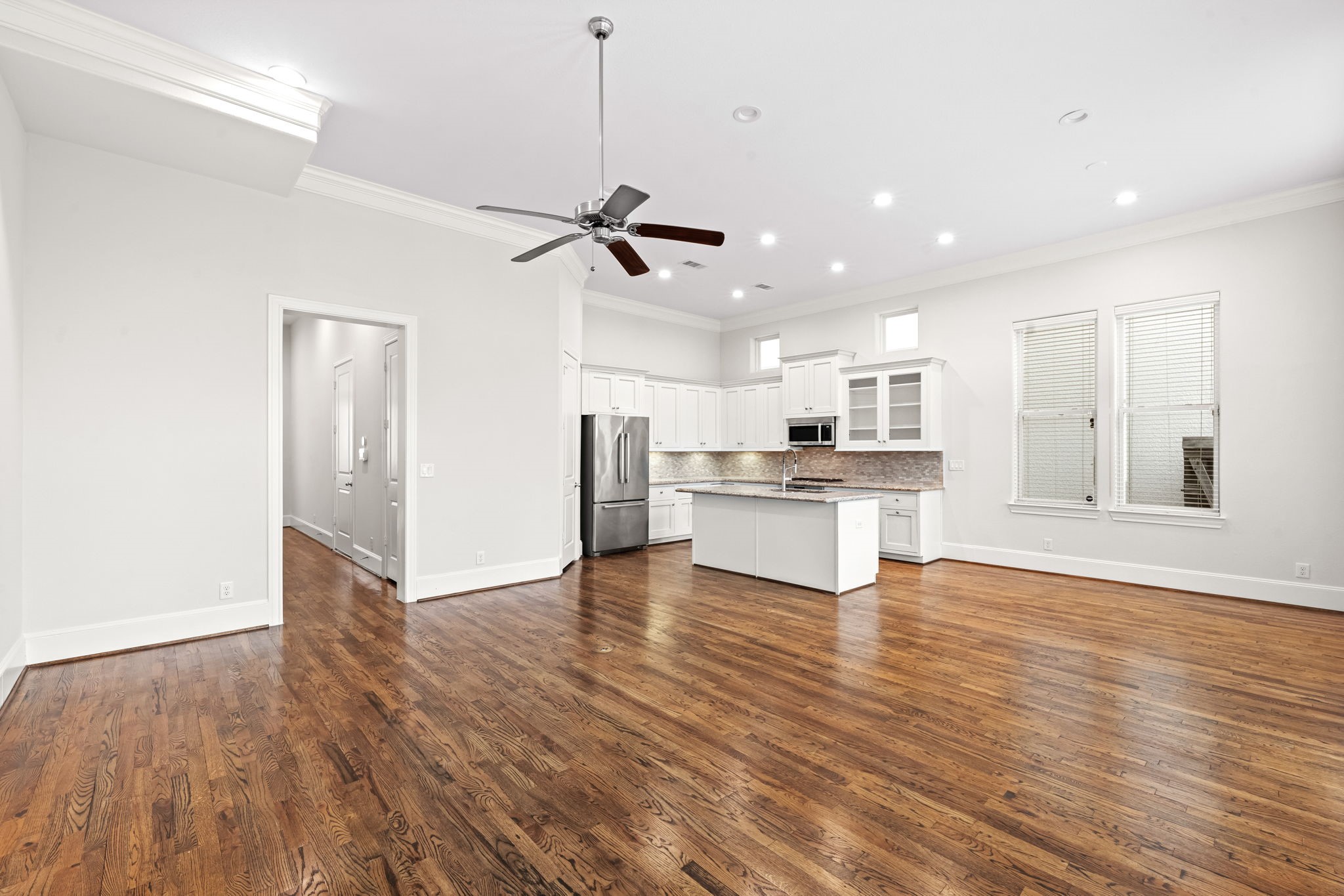 5621 Cohn Meadow Lane Houston, TX 77007 - Photo 5 of 35 Light-filled first-floor living space with soaring ceilings, rich hardwood floors, and seamless open-concept design connecting the kitchen and dining areas.