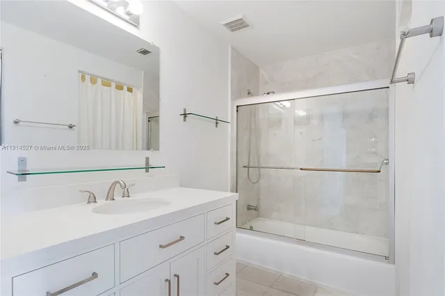 a bathroom with a shower sink and mirror