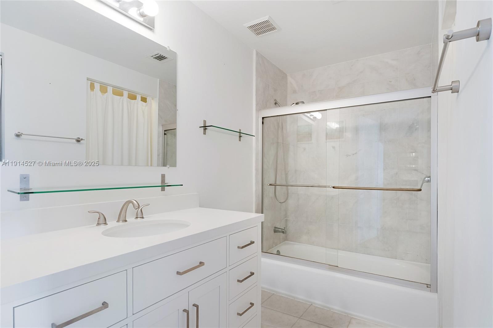 725 Northeast 22nd Street, Unit 17E Miami, FL 33137 - Photo 12 of 15 a bathroom with a shower sink and mirror