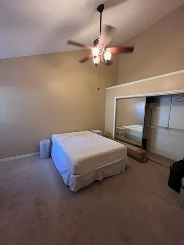 a spacious bedroom with a bed and a chandelier