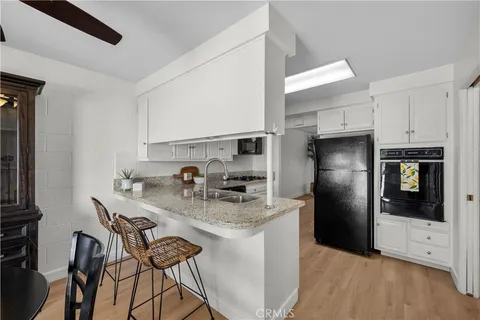 a kitchen with stainless steel appliances granite countertop a refrigerator and a stove top oven