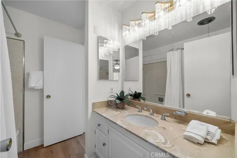 a bathroom with a granite countertop double vanity sink and a mirror