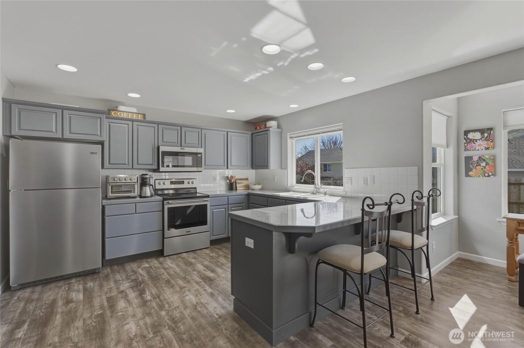 2217 Michael Brooke Wenatchee, WA 98801 - Photo 15 of 37 a kitchen with a refrigerator a stove a sink a dining table and chairs