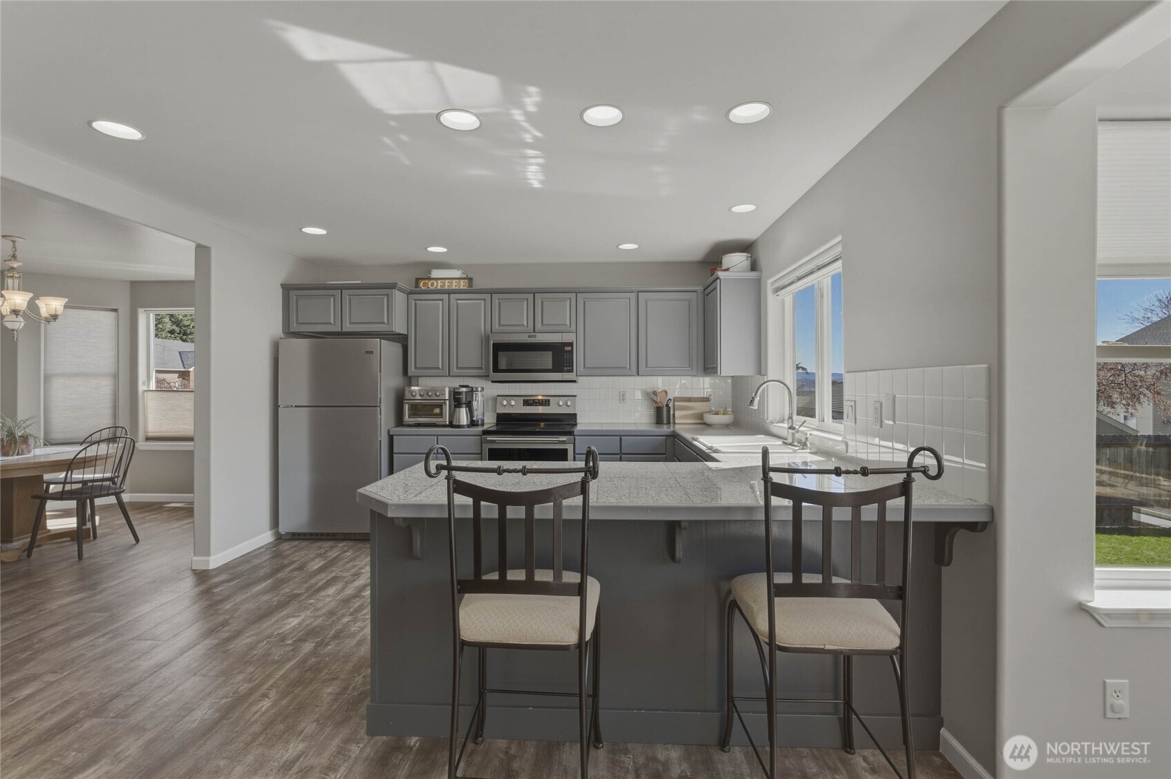 2217 Michael Brooke Wenatchee, WA 98801 - Photo 16 of 37 a kitchen with stainless steel appliances a dining table chairs refrigerator and microwave