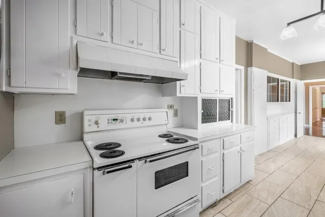 a kitchen with granite countertop white cabinets and white appliances