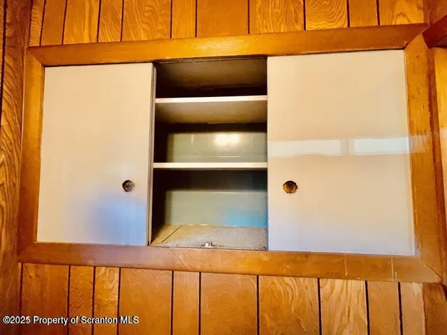 a view of empty room with a fireplace and chandelier
