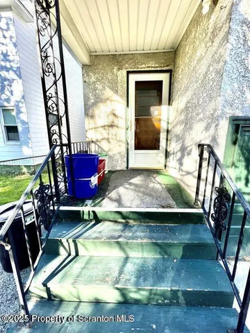 a view of a white house with a large space and a car parked in front of it