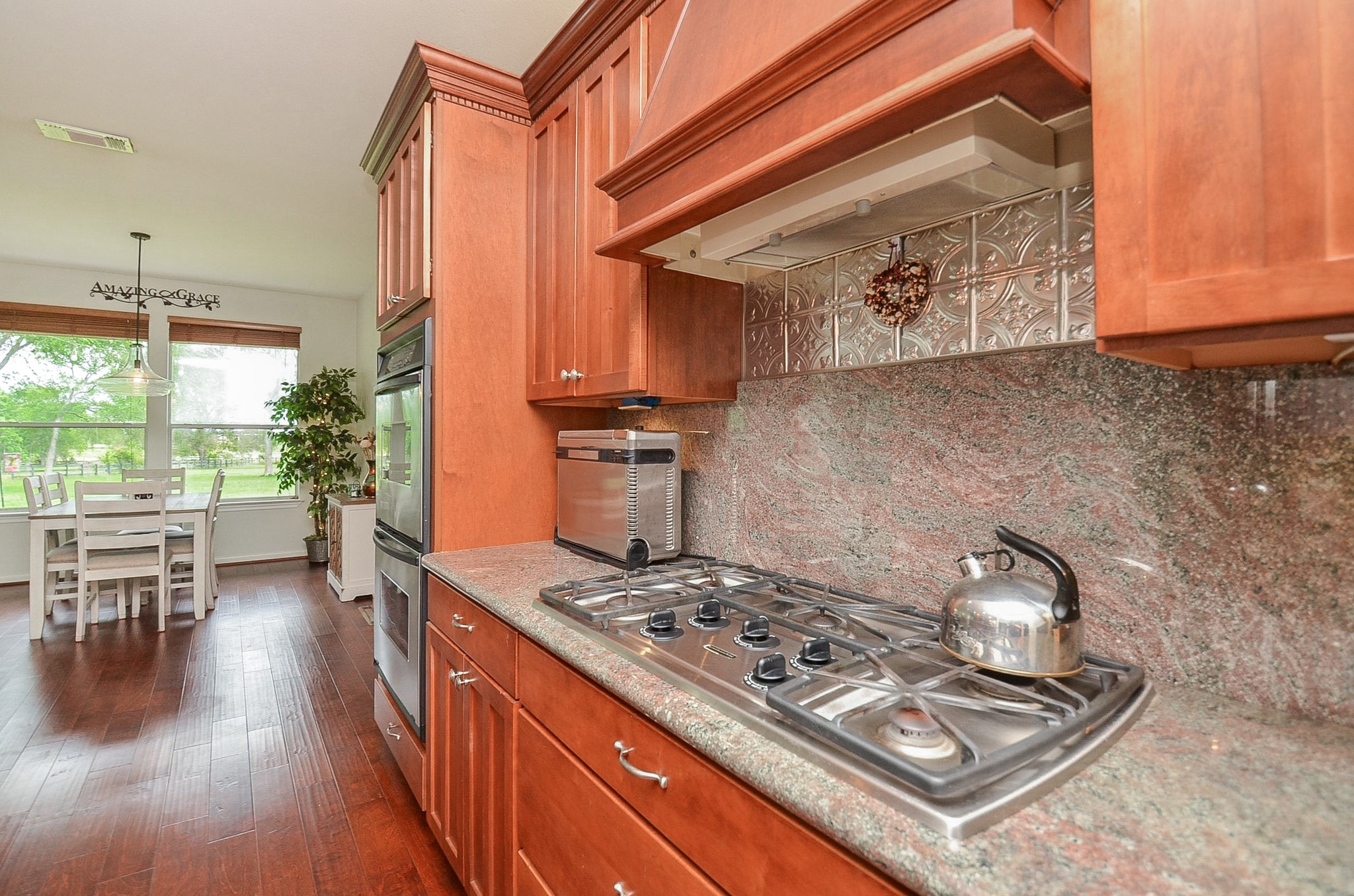 27644 Spring Hill Road Hempstead, TX 77445 - Photo 14 of 50 Gorgeous, gradient tile backsplash is highlighted by artisan craftsmanship above the shining, set-in cook top.