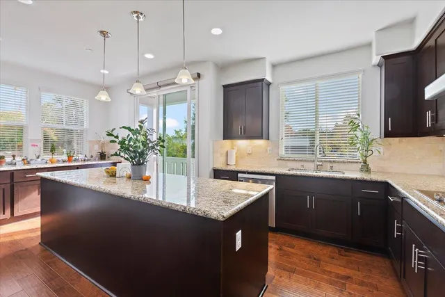 a kitchen with granite countertop a sink a counter top space and cabinets
