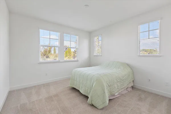 a bed sitting in a bedroom next to a window