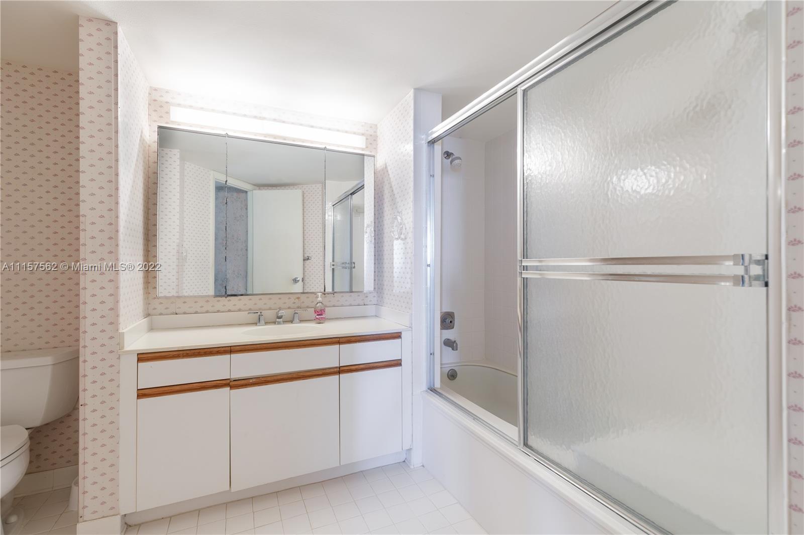 450 Ocean Drive, Unit 305 Juno Beach, FL 33408 - Photo 17 of 30 a bathroom with a bathtub sink vanity and mirror