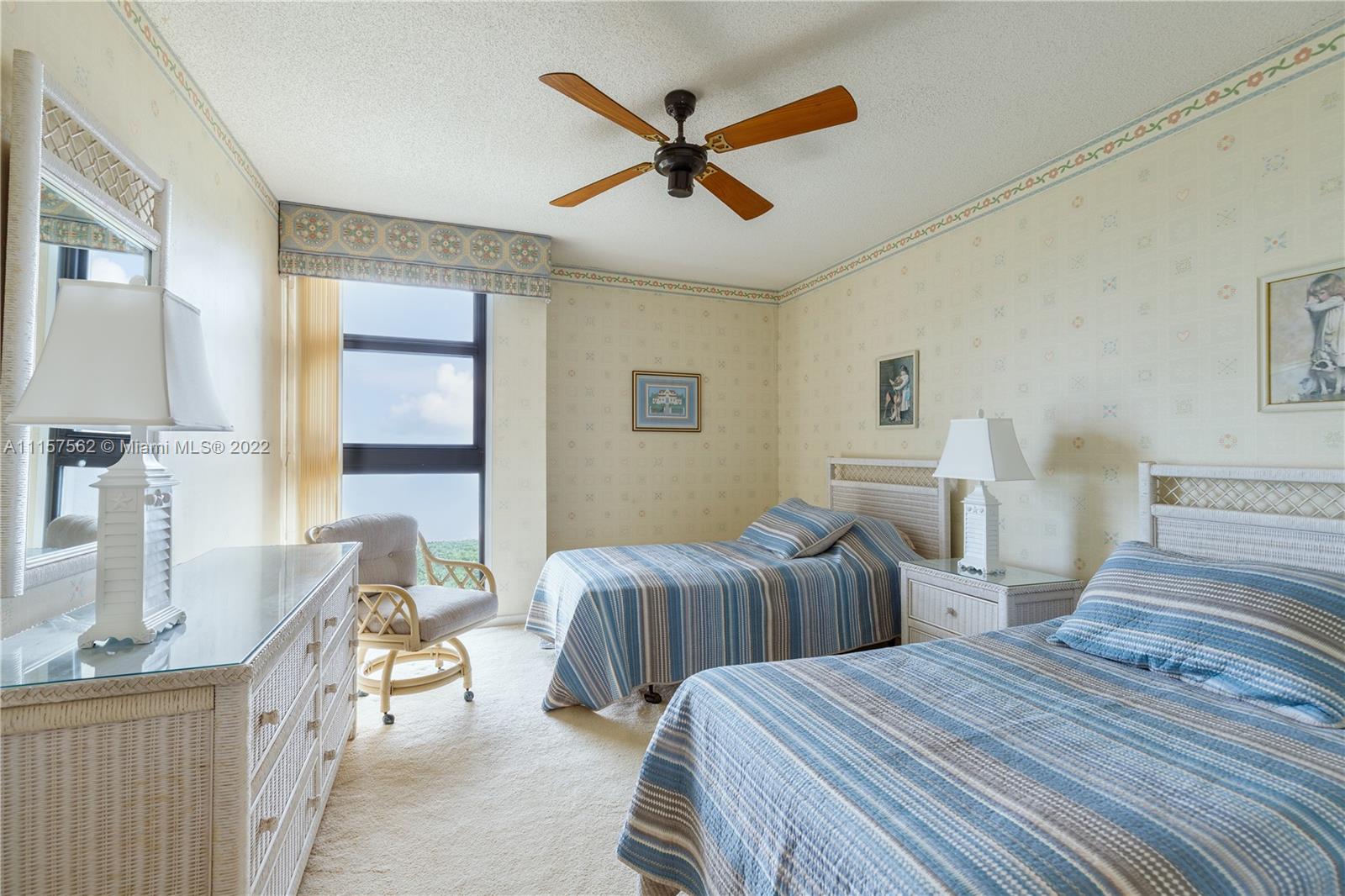 450 Ocean Drive, Unit 305 Juno Beach, FL 33408 - Photo 18 of 30 a bedroom with two beds and a chandelier