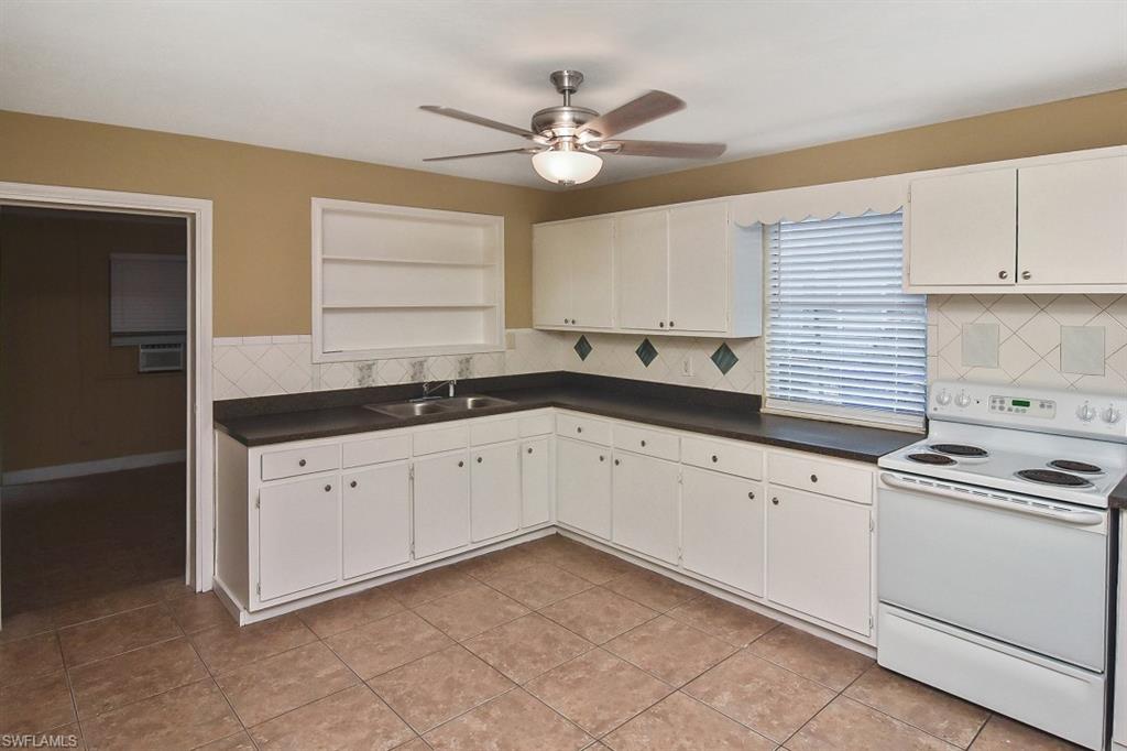 3966 Madison Avenue Fort Myers, FL 33916 - Photo 12 of 22 a kitchen with granite countertop white cabinets white stainless steel appliances with a sink and dishwasher