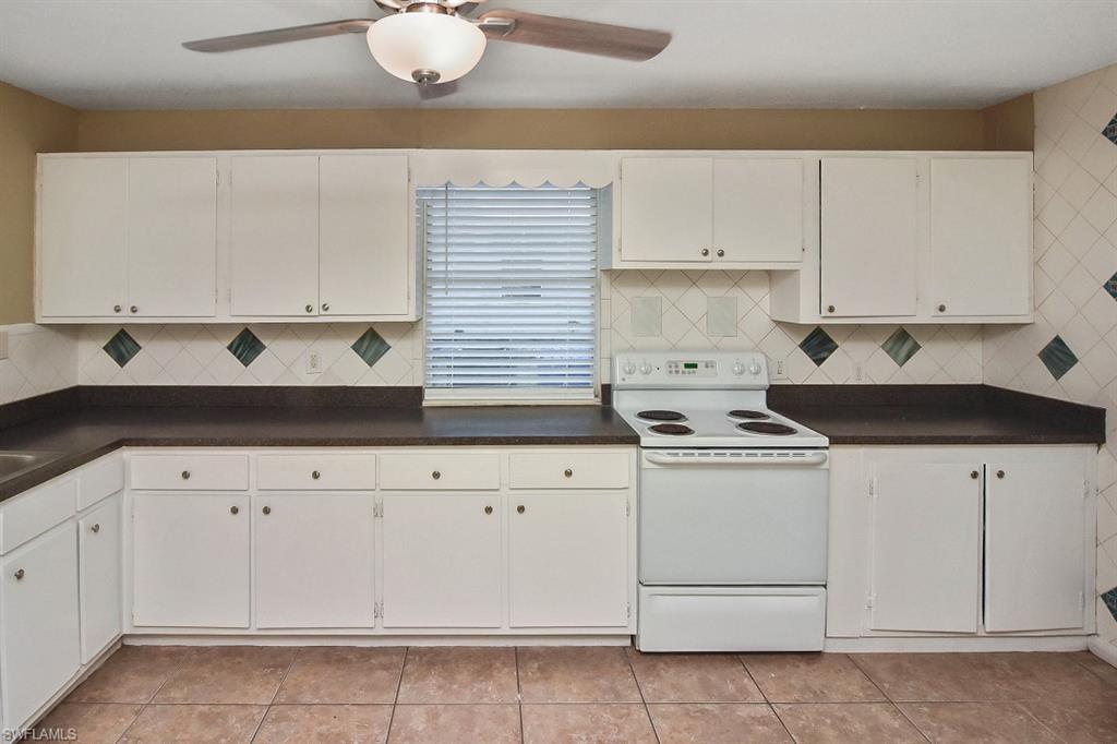 3966 Madison Avenue Fort Myers, FL 33916 - Photo 14 of 22 a kitchen with granite countertop white cabinets and white appliances