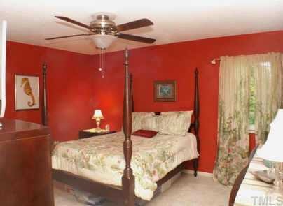 1105 Terrace Court Raleigh, NC 27615 - Photo 6 of 12 a bedroom with a bed and a chandelier