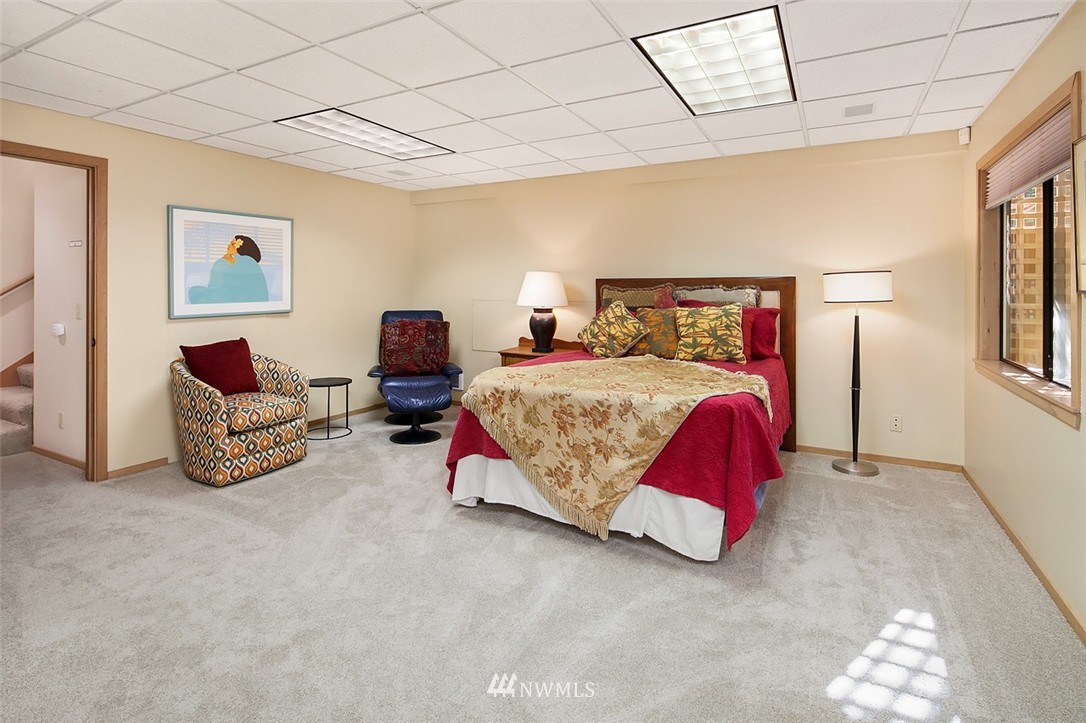 4453 East Mercer Way Mercer Island, WA 98040 - Photo 22 of 25 a bedroom with bed and a chandelier