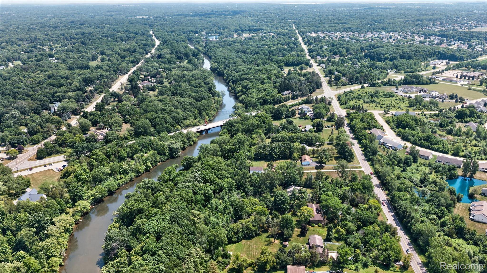 7186 East River Road Flushing, MI 48433 - Photo 29 of 47 Expansive landscape featuring dense tree coverage, a meandering river, and surrounding residential areas