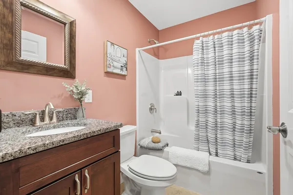 a bathroom with a granite countertop sink toilet and shower