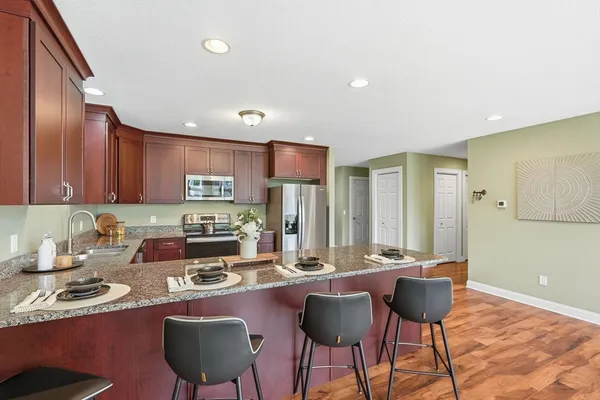 a kitchen with granite countertop a sink and a stove top oven with wooden floor