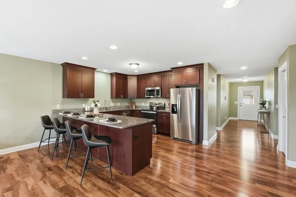 a kitchen with stainless steel appliances granite countertop a stove refrigerator and a dining table
