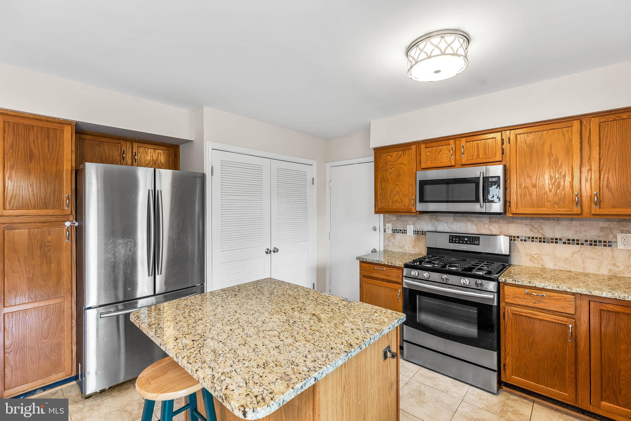 1868 Middlebridge Drive Silver Spring, MD 20906 - Photo 4 of 50 a kitchen with stainless steel appliances granite countertop a refrigerator stove and microwave