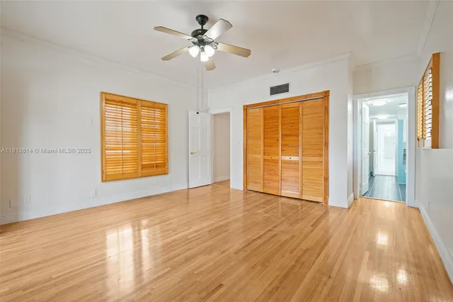 an empty room with fan and entrance