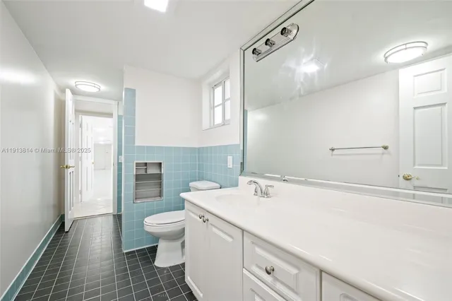 a bathroom with a toilet sink and a mirror