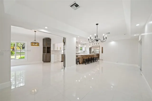 a kitchen with white cabinets and chairs