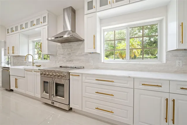 a view of an empty room with wooden floor fireplace and a window
