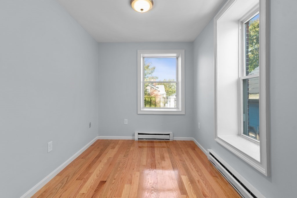 2 Woodbine Street, Unit 2 Boston, MA 02119 - Photo 17 of 26 wooden floor in an empty room with a window