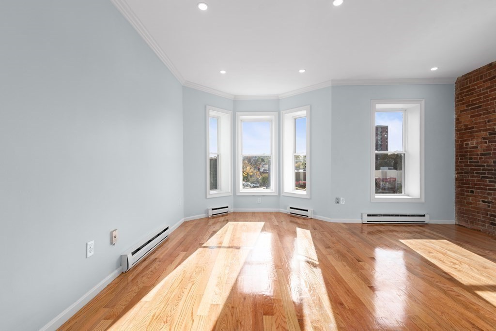 2 Woodbine Street, Unit 2 Boston, MA 02119 - Photo 5 of 26 a view of an empty room with a window and wooden floor