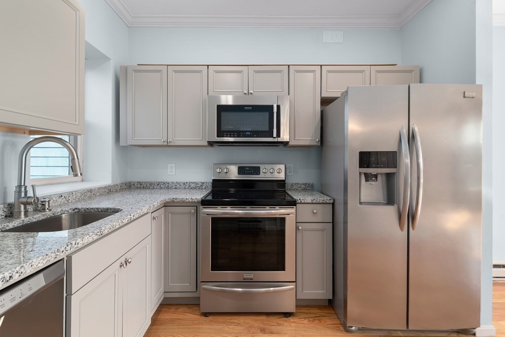 2 Woodbine Street, Unit 2 Boston, MA 02119 - Photo 9 of 26 a kitchen with stainless steel appliances granite countertop a stove a refrigerator and a sink