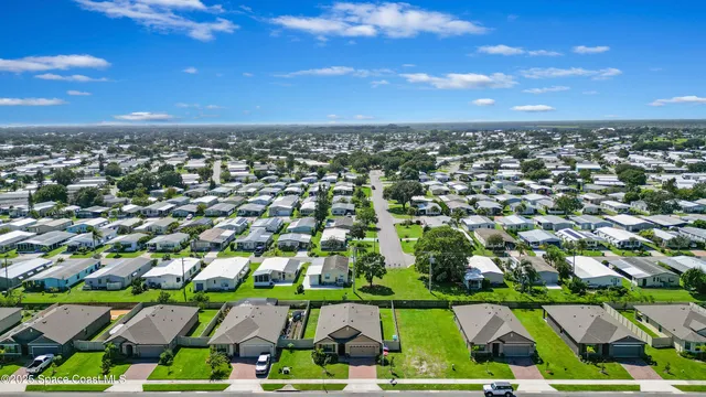 an aerial view of residential houses with outdoor space and trees