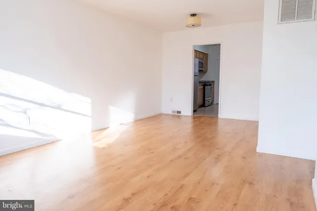 a view of a hallway with wooden floor and entryway